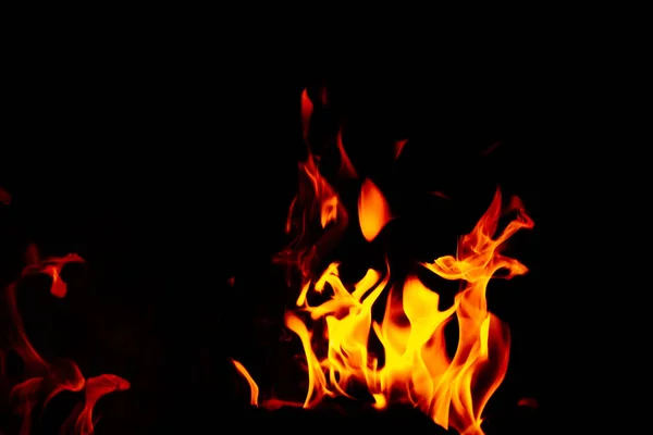 黒い背景の燃え立つ炎の見事なショット — ストック写真