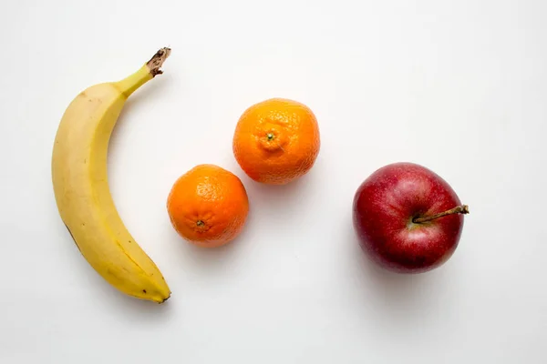 Uma Colocação Chata Uma Banana Laranjas Uma Maçã Superfície Branca — Fotografia de Stock