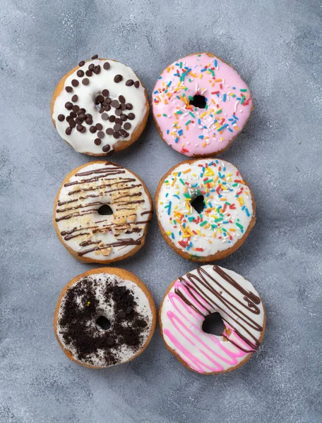 Ein Vertikaler Schuss Glasierter Donuts Mit Verschiedenen Glasuren Und Belägen — Stockfoto