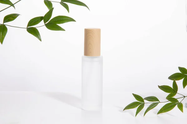 Eine Einzige Hautpflegeflasche Auf Weißem Hintergrund Mit Grünen Blättern — Stockfoto