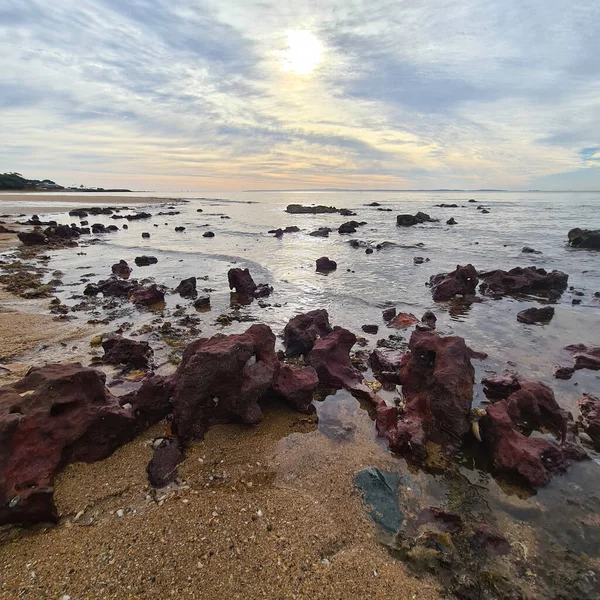 美丽的云彩笼罩着平静无浪的大海 有岩石般的海岸线 — 图库照片