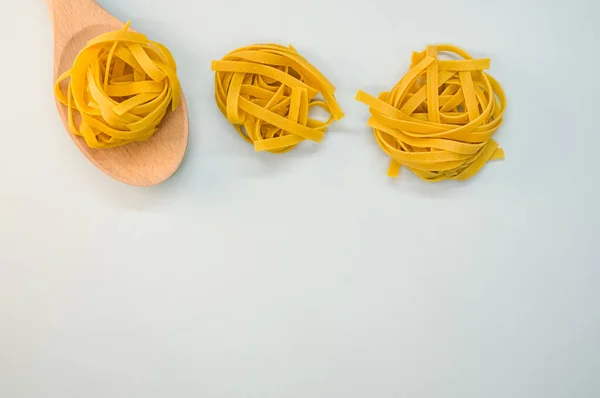 Eine Nahaufnahme Von Tagliatelle Pasta Und Einem Hölzernen Küchenwerkzeug — Stockfoto