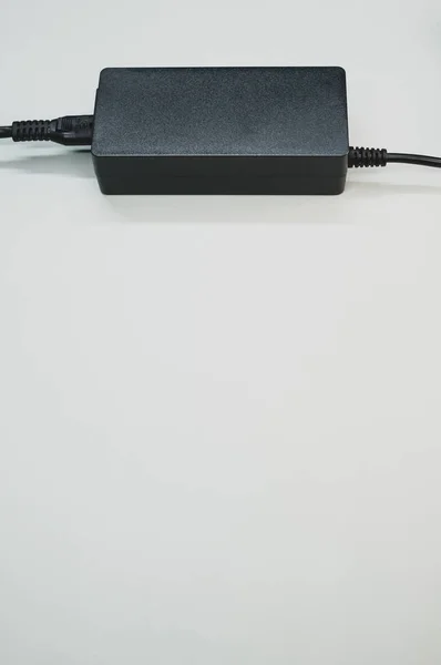 灰色の背景に隔離されたラップトップ充電器の垂直ショット — ストック写真