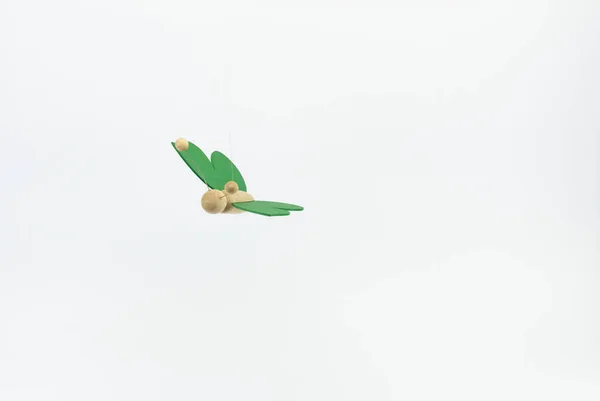 一只木制小蝴蝶的特写镜头 它的翅膀是绿色的 背景是灰色的 — 图库照片