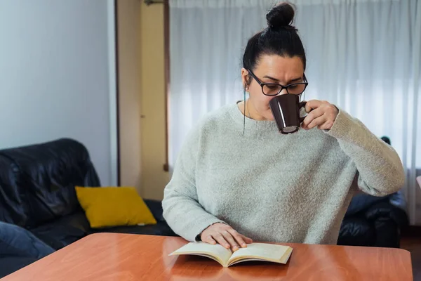 Μια Γυναίκα Που Διαβάζει Ένα Βιβλίο Και Πίνει Καφέ — Φωτογραφία Αρχείου