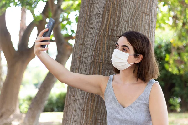 Жінка Носить Обличчя Приймає Селфі Телефоном Парку — стокове фото