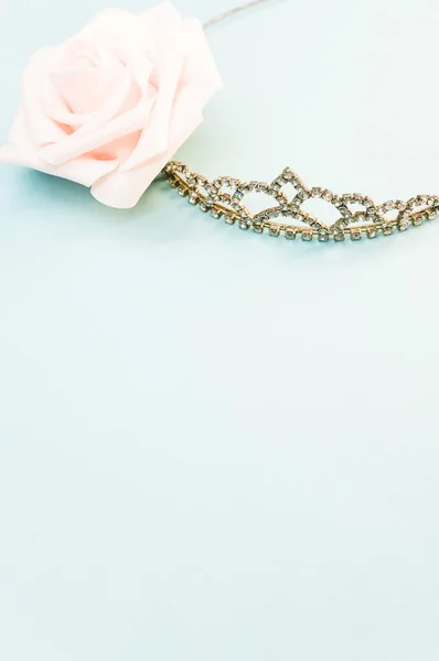 Вертикальный Снимок Элегантной Короны Рядом Декоративной Розой Синем Фоне — стоковое фото