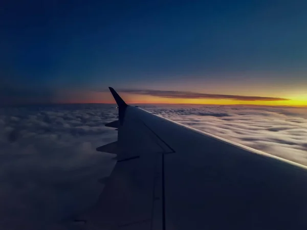 落日时在云天上空飞行的飞机机翼的特写 很适合壁纸 — 图库照片