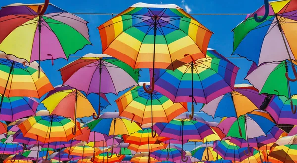 Regenbogenfarbene Regenschirme Hängen Vor Dem Hintergrund Eines Blauen Himmels — Stockfoto