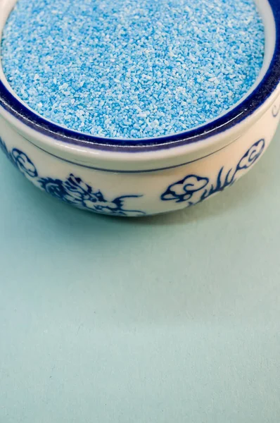 Вертикальный Снимок Голубого Песка Фарфоровой Чаше Белой Поверхности — стоковое фото