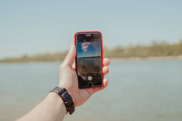 Penutup Dari Seseorang Memegang Smartphone Merah Dan Mengambil Foto Dari — Stok Foto