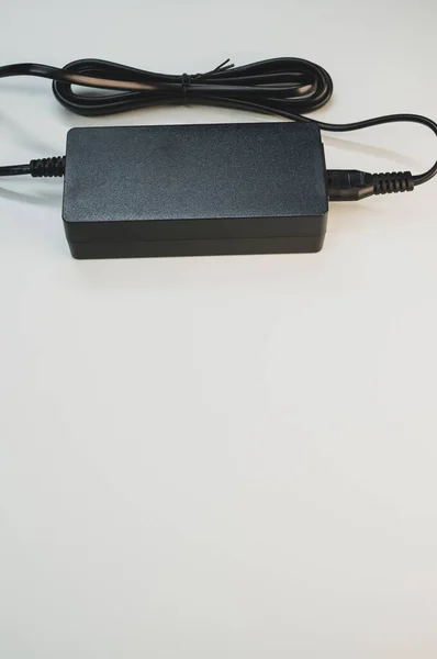 灰色の背景に隔離されたラップトップ充電器の垂直ショット — ストック写真