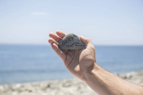 Uma Mão Segura Uma Pedra Que Diz Palavra Surf Fundo — Fotografia de Stock
