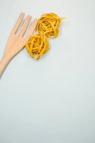 Een Verticaal Shot Van Tagliatelle Pasta Een Houten Keukengereedschap — Stockfoto