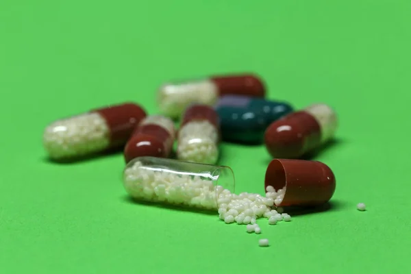 Közelkép Kapszulázott Tablettákról Zöld Felületen — Stock Fotó