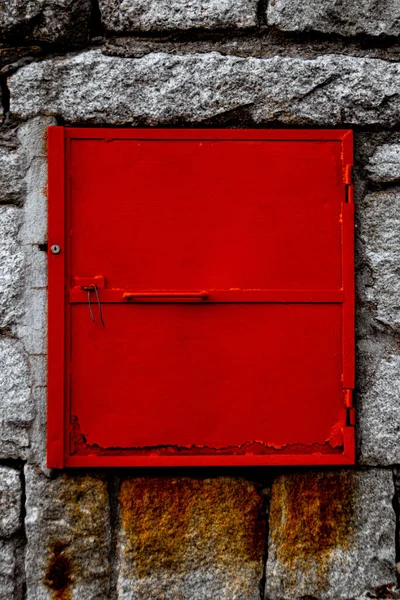 石垣の上に錆びた赤い鉄の扉が閉じられた — ストック写真