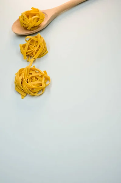 Ein Vertikaler Schuss Tagliatelle Pasta Und Ein Hölzernes Küchenwerkzeug — Stockfoto