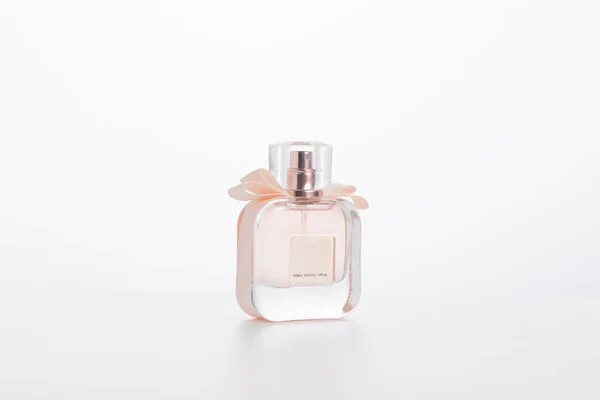 Uma Garrafa Perfume Rosa Elegante Com Arco Isolado Fundo Branco — Fotografia de Stock