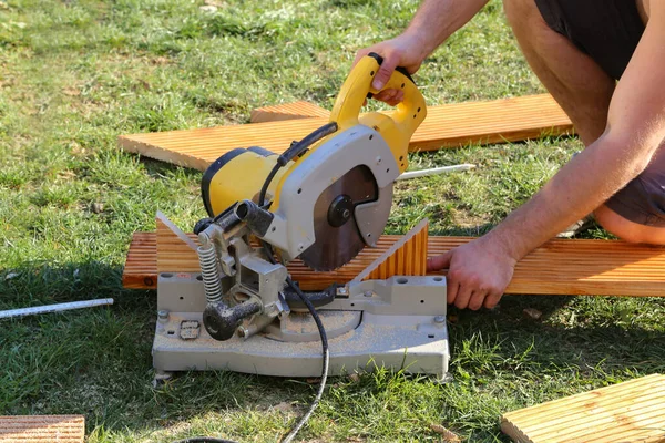 Primer Plano Trabajador Construcción Cortando Madera Con Una Sierra — Foto de Stock