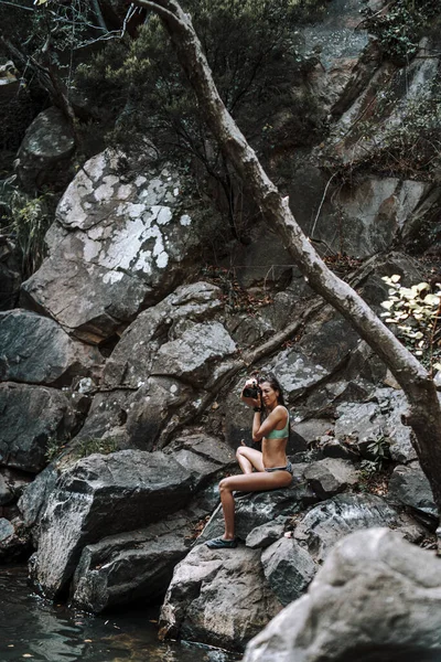 一位年轻貌美的女子在森林的瀑布前拍照 — 图库照片