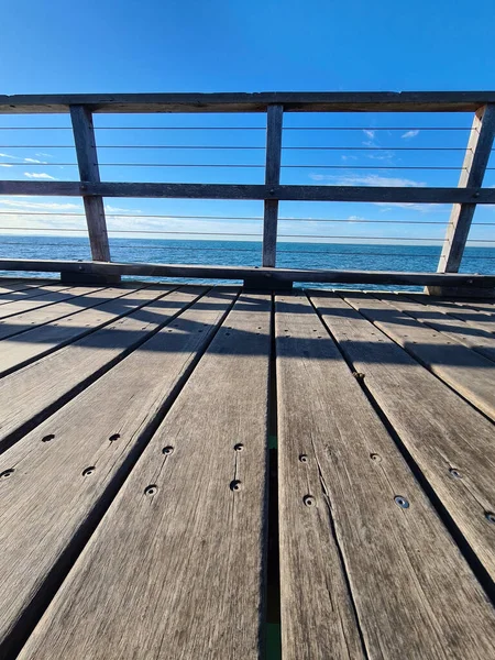 海に架かる木製の橋の垂直ショット — ストック写真