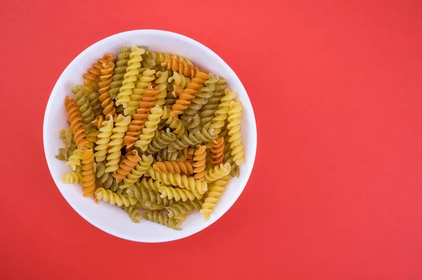 Pasta Fusilli Tazón Superficie Roja —  Fotos de Stock