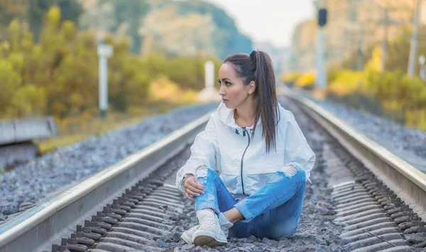 Красива Молода Самотня Жінка Білому Піджаку Джинсах Сидить Залізничній Колії — стокове фото