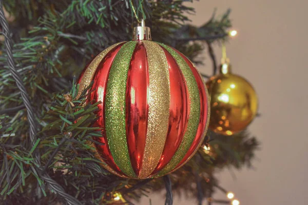 クリスマスツリーの上に赤と金色のストライプの美しい泡のクローズアップショット — ストック写真
