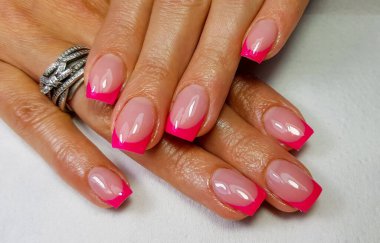 A closeup of a simple pink french manicure on square-shaped nails clipart