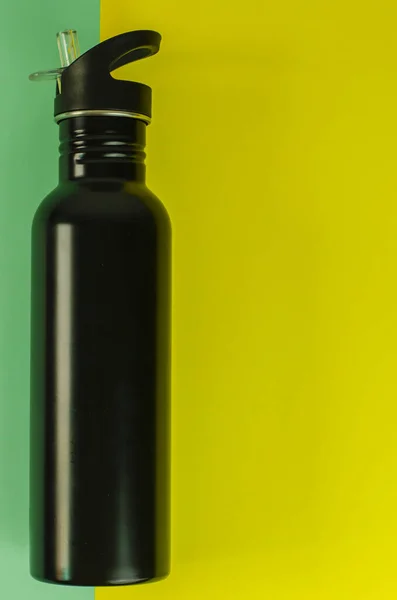 健康垫上的一个黑色瓶子的垂直镜头 — 图库照片