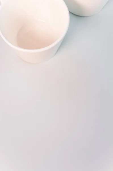 Вертикальный Снимок Пустых Белых Кофейных Чашек Размещенных Белой Поверхности — стоковое фото