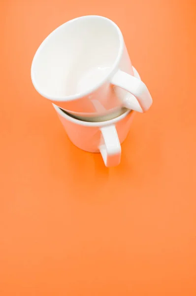 Eine Vertikale Aufnahme Von Zwei Leeren Tassen Auf Orangefarbener Oberfläche — Stockfoto
