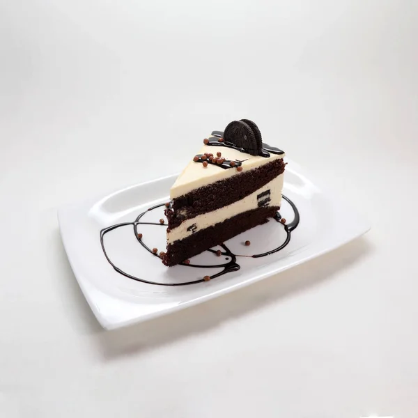 白い背景に隔離されたプレート上にビスケットとチョコレートケーキの作品のクローズアップ — ストック写真