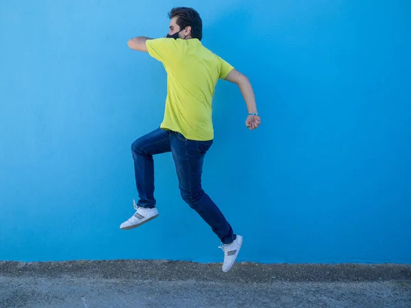 Młody Biały Mężczyzna Masce Medycznej Skaczący Niebieską Ścianę Andaluzji Hiszpania — Zdjęcie stockowe