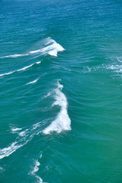 明るい緑の水の中の波の垂直ショット — ストック写真
