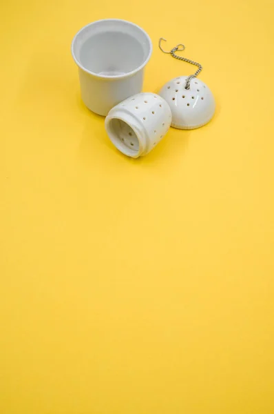 Eine Vertikale Aufnahme Eines Weißen Teesiebs Und Eines Teebeutels Isoliert — Stockfoto