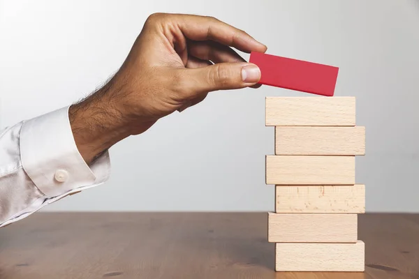 Una Mano Umana Che Mette Blocco Rosso Legno Sul Mucchio — Foto Stock