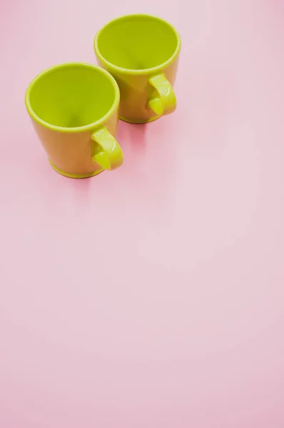 薄いピンクの背景に2つの薄緑のマグカップ — ストック写真
