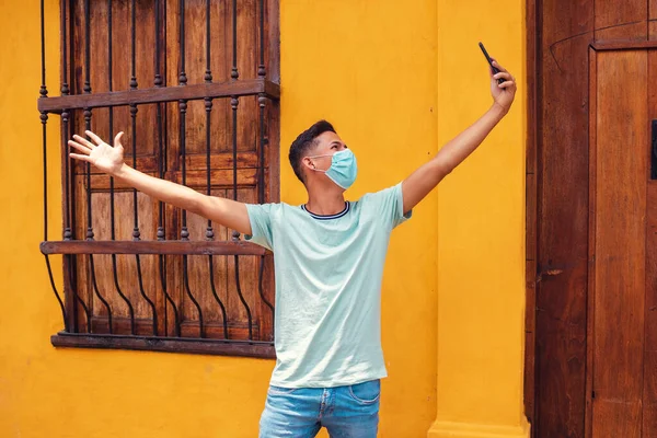 Young Hispanic Man Wearing Surgical Mask While Taking Selfie Yellow — Stock Photo, Image