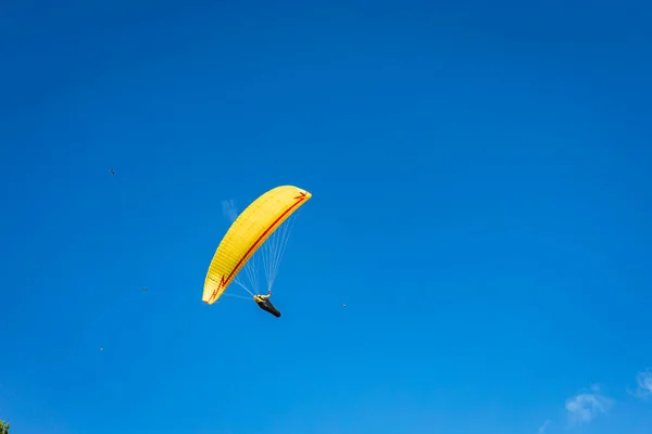 Paralotnia Jasnożółtym Spadochronem Przeciwko Błękitnemu Niebu — Zdjęcie stockowe
