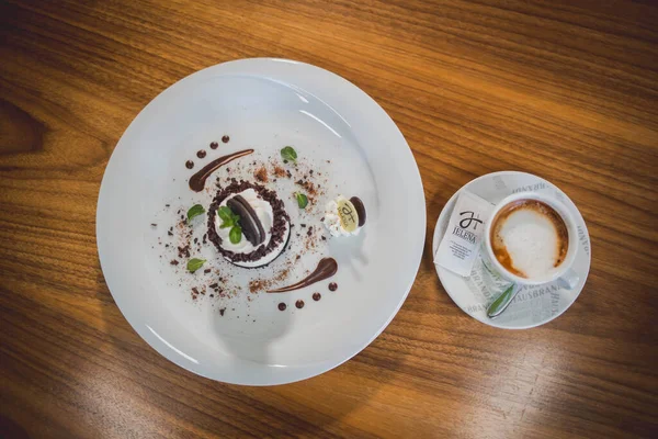 木製のテーブルの上にホットコーヒーと一緒に提供されるノーベークの小さなチーズケーキのトップビュー — ストック写真