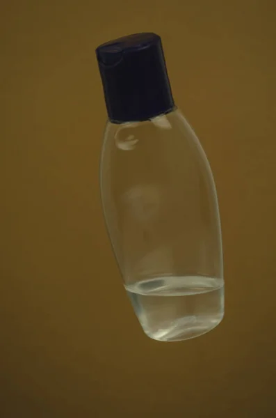 Disparo Vertical Una Botella Agua Sobre Fondo Marrón —  Fotos de Stock
