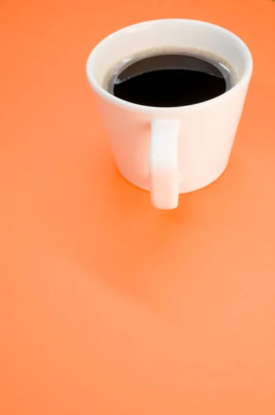Colpo Verticale Una Tazza Caffè Nero Una Superficie Arancione — Foto Stock