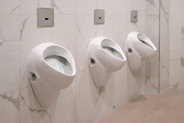 Ряд Трех Керамических Писсуаров Мраморном Интерьере Общественных Туалетов — стоковое фото