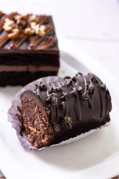 一个小巧克力蛋糕卷的软焦点 顶部有巧克力片和一块方块蛋糕作为背景 — 图库照片