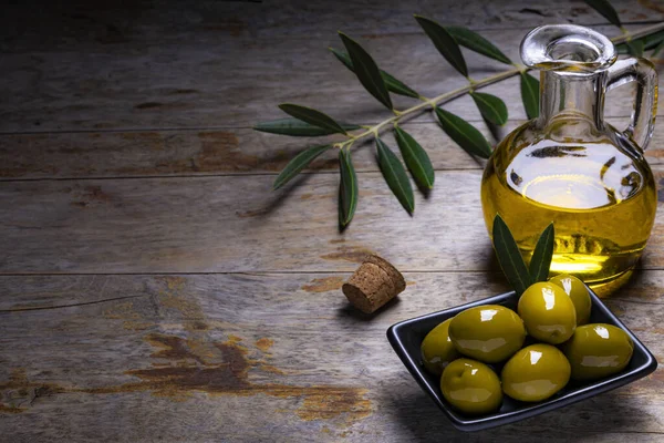 Lekkere Olijven Extra Vierge Olijfolie Olijfbladeren Donkere Houten Ondergrond — Stockfoto