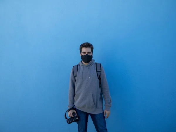 Een Jonge Europese Man Staat Tegen Een Blauwe Muur Met — Stockfoto