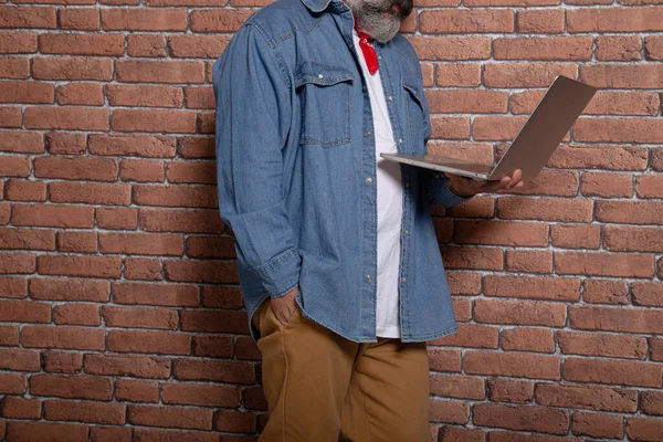 Kaukasisk Man Som Använder Sin Laptop Vid Tegelvägg — Stockfoto