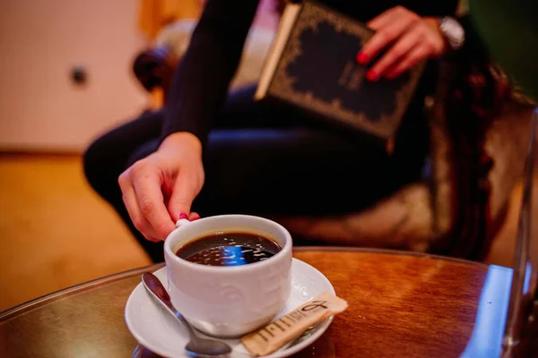 여자가 읽다가 커피를 마시는 장면을 선택적으로 집중하는 — 스톡 사진