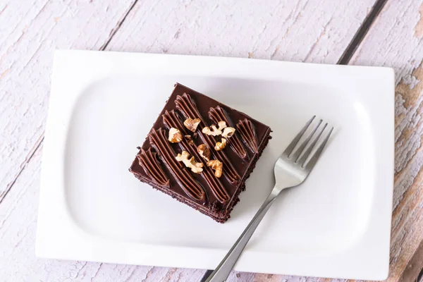 Plano Una Rebanada Pastel Chocolate Cubierto Con Nueces Plato Cerámica — Foto de Stock